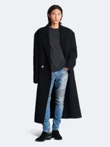 Remera gris oscuro de algodón con cuello redondo y mangas cortas. Estampado frontal con el logo de Balmain en relieve.