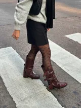 Borcegos de cuero color chocolate con efecto gastado. Caña alta con tres correas con hebillas plateadas. Taco bajo. Industria Argentina.