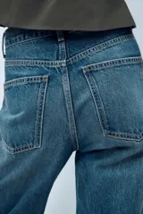 Pantalón de jean azul de corte wide leg, tiro alto y largo hasta el tobillo.