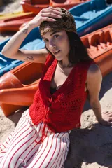 Chaleco corto tejido a crochet color verde oliva, con escote en V y cierre frontal con lazos.