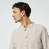 Camisa de lino color beige, de manga larga y cuello mao.