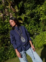 Camisa azul marino de lino, con cuello mao, abotonada al frente y mangas largas con puños abotonados. Tiene un lazo en la cintura para fruncir.