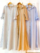 Vestido camisero largo a rayas verticales, con cuello camisero, mangas largas con puños abotonados y cierre frontal con botones.