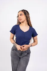 Remera corta de punto canalé color rosa, con escote en V, mangas cortas con volados y cierre frontal con botones.