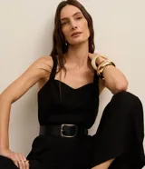 Mono de mujer color rojo oscuro (bordó), de corte recto y pierna ancha, con escote corazón y tirantes anchos con elástico. Presenta pliegues frontales que caen rectos hasta el ruedo.