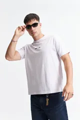 Remera lila de manga corta con cuello redondo y logo estampado en el frente.