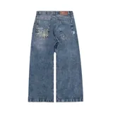 Pantalón de jean azul desgastado, corte mega baggy, con bordado dorado en el bolsillo trasero y botones personalizados.