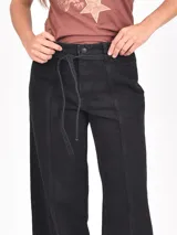Pantalón de jean negro de tiro alto, corte ancho y pierna recta, con costuras verticales marcadas en el frente y cordón ajustable en la cintura.