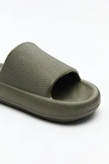 Sandalia chata color verde militar, con capellada ancha y suela plana.