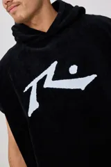 Poncho con capucha confeccionado en tejido de toalla de algodón, color negro, con el logo de la marca Rusty bordado en blanco en el frente.