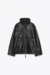 Cazadora bomber de cuero color marrón, con cuello alto, manga larga y bolsillos de parche con solapa en el delantero. Cierre frontal con cremallera metálica y botones a presión ocultos por solapa.