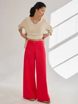 Pantalón negro de pierna ancha con tiro medio alto y pretina elastizada en la espalda. Presenta bolsillos plaque en delantera y espalda.