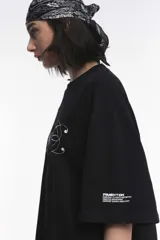 Remera blanca de algodón con cuello redondo y manga corta. Estampado pequeño de un ají rojo en el centro del pecho.