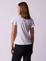 Remera blanca texturizada con cuello redondo y aplique de crochet. Mangas cortas amplias.