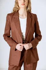 Blazer marrón con solapas de muesca, cierre frontal con botones y corte recto.