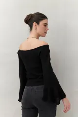 Top tejido color beige con escote off-shoulder y mangas largas acampanadas.