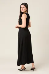 Vestido camisero largo sin mangas color negro, con cuello en V y cierre de botones delanteros. Incluye cinturón ancho a tono y bolsillos estilo safari en el pecho.