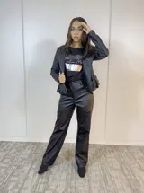 Chaqueta negra de eco cuero con cierre lateral plateado y volados en la espalda baja.