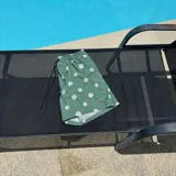 Short de baño negro con estampado de margaritas blancas, cintura elástica con cordón ajustable y logo de la marca en la pierna derecha.