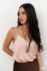 Musculosa de tirantes delgados con diseño bicolor: la parte superior es de color crema y la parte inferior es de color rosado pálido, ambas con acabado satinado.