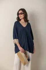 Blusa italiana tipo poncho color azul marino con escote en V y lurex dorado en el cuello y puños.