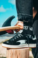 Championes negros de gamuza con detalles en blanco, suela blanca con base color caramelo y cordones negros.