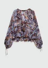 Blusa de gasa estampada con motivos paisley en tonos marrón, celeste y rosa. Tiene escote en V con volantes, mangas largas con puños elásticos y corte holgado.
