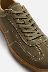 Zapatillas de cordones color verde oliva, de estilo retro. Parte superior fabricada en piel con acabado serraje y suela en contraste color caramelo.