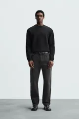 Sweater negro de punto con cuello redondo y mangas largas.