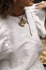 Blusa negra de lino con volados en los hombros y pespuntes en color beige.