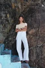 Top de punto color crema, de cuello redondo y manga corta con detalle de vivos a contraste en cuello y hombros.