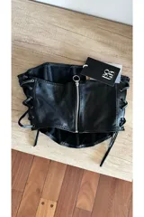 Top corset negro de cuero ovino con cordones laterales.