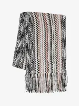 Bufanda larga Missoni con patrón de zigzag en tonos blanco, negro, marrón y naranja, y flecos en los extremos.