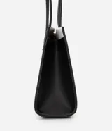 Cartera shoulder mediana de cuero sintético, con diseño bicolor blanco y negro y detalles metálicos dorados.