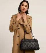 Bolso bandolera negro acolchado con patrón de rombos, asa de cadena y cierre de cremallera.