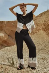 Blusa negra con diseño tie dye en gris y blanco, de manga corta y corte irregular.