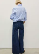 Pantalón de jean azul oscuro, de corte wideleg, tiro alto y bolsillos de parche frontales.