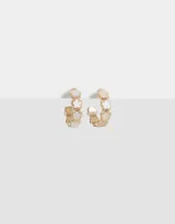 Aros tipo argolla dorados con flores esmaltadas color blanco.
