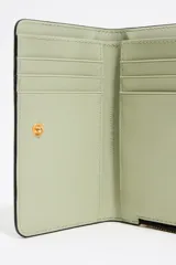 Monedero negro con textura brillante y estructura rígida. Cuenta con tirador de tejido, logo metálico BIMBA Y LOLA, acabados metálicos, tarjetero y monedero interior, cierre de cremallera e interior con logo grabado.