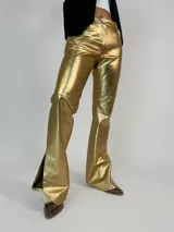 Pantalón de cuero dorado, corte recto con aberturas en el ruedo.