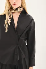 Camisa amplia de poplin color beige, con botones laterales para abotonar de forma cruzada.