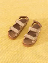 Sandalias bajas color beige con tiras de rafia y ajuste con velcro.