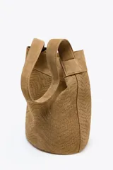 Bolso tipo maxi saca color marrón claro, de cuero trenzado, con asa de hombro y bolsillo interior.