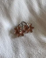 Par de aros dorados con forma de estrella negra.