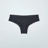 Pack de tres braguitas brasileñas de microfibra con cintura de encaje: una negra con estampado de lunares rosas, una negra lisa y una con estampado de camuflaje en tonos verde y negro.