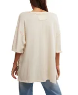 Remera color crema de corte holgado, con cuello redondo y mangas cortas. Estampado frontal con un corazón atravesado por una flecha y rosas rojas.