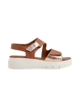 Sandalia marrón con plataforma blanca, tiras de cuero metalizado color cobre y ajuste con velcro.