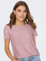 Camiseta rosa con pequeños calados, de manga corta y cuello redondo.