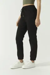 Pantalón deportivo de tiro alto con cintura ajustable y puños, diseño negro.