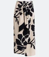 Pollera midi color beige con estampado floral negro, lazo en la cintura y tajo lateral.